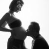 Фотосессия беременных, в студии, пара на белом фоне, мужчина целует девушку в живот