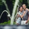 Love story фотосессия, на природе, прогулка по Киеву, пара обнимается напротив фонтана и струй воды