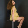 Фотосессия беременных в студии, фотограф Постникова Алиса, модель Анастасия Войцеховская сидящая на высоком стуле на черном фоне